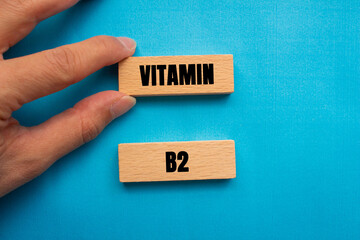 Vitamin B2 message written on wooden blocks on blue background. Conceptual Vitamin B2 symbol. Copy...