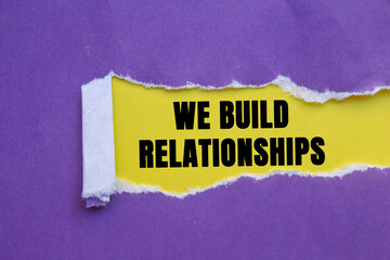 We Build Relationships message written on ripped torn purple paper on yellow background. Conceptual We Build Relationships symbol. Copy space.
