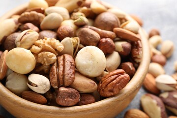Mix of different nuts in bowl on table, closeup