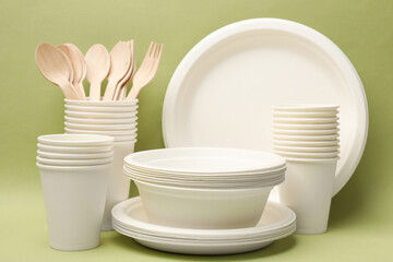 Obraz na płótnie Canvas Set of disposable tableware on green background
