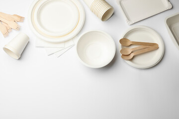 Set of disposable tableware and napkins on white background, flat lay