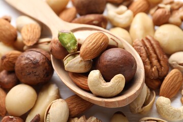 Mix of different nuts and spoon on table, closeup