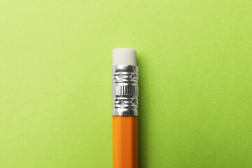 One graphite pencil on light green background, top view