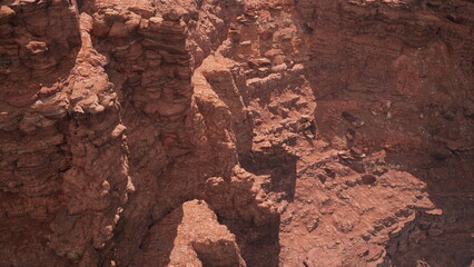 Exploring the intricate layers of a stunning canyon, sunlight casts shadows that highlight the rich textures of red rock. This breathtaking landscape reveals natures artistic craftsmanship over time.
