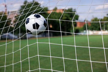 Hitting soccer ball in net outdoors, closeup. Football game