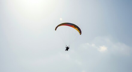 Paraglider flying in blue sky