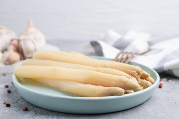 Pickled asparagus and spices on grey table, closeup