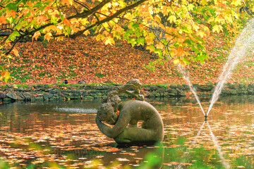 Fountain and sculpture of naked woman "Lileya" on lake in autumn Stryisky park in Lviv, Ukraine © dmf87