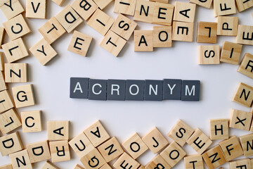 Acronym word in wooden cube blocks, abbreviation concept, short form of words, language and communication idea