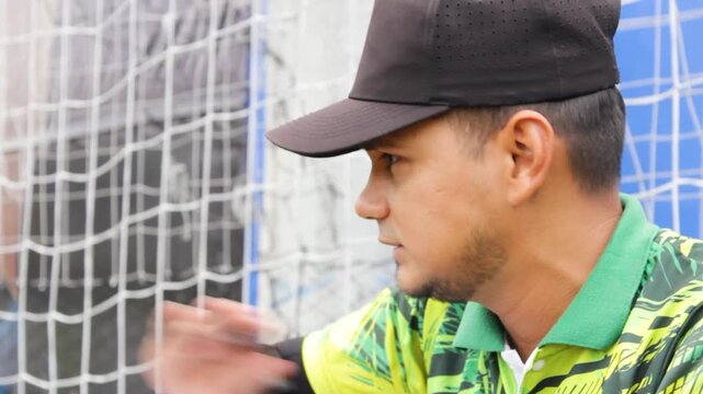 Portrait of a young Hispanic instructor calling his students' attendance before a soccer training session inside a sports center in Neiva, Huila, Colombia. Concept of work and education