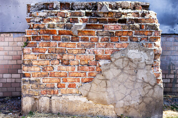 A weathered, crumbling brick wall with peeling plaster, a vivid symbol of urban decay. The texture and destruction are highlighted, showing the passage of time.

