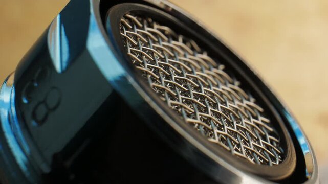 Iron filter mesh showing weaving pattern. Thin wire interlacement demonstrates textile principles in metal form. Decorative industrial design