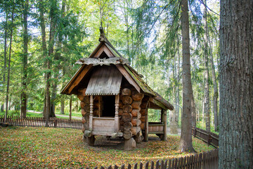 A wooden house standing on wooden stumps, a hut on chicken legs made of large logs in the forest. Sights of Russia, World tourism.
