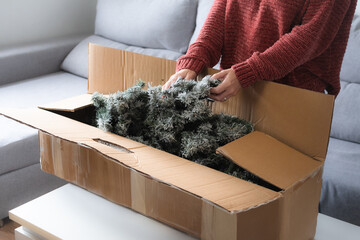 Woman unpacking Artificial Christmas Tree from Storage Box