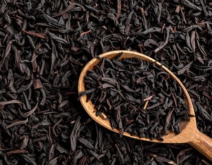 Wooden spoon filled with loose black tea