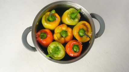 Colorful bell peppers filled minced meat rotating in cooking saucepan on kitchen table, top view. Meat vegetable ingredients, culinary techniques, homemade cook preparing healthy food. - Powered by Adobe