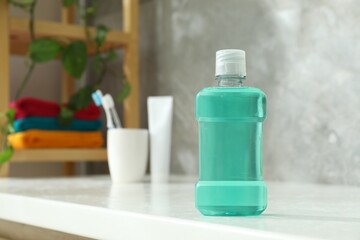 Bottle of mouthwash on white counter in bathroom. Space for text