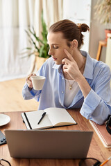 Young man enjoys coffee while reflecting in a cozy workspace filled with natural light