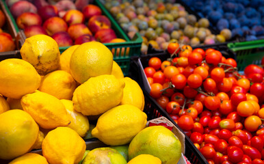 Fresh fruit and vegetables at a market stall in Porto with tomatoes, nectarines, plums, and lemons. Typical fruits of the region are offered for sale. Colorful shot with selective focus.