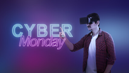 Indonesian southeast asian man in virtual reality glasses touching a text of Cyber Monday on a color gradient background. Copy space. Cyber Monday sale concept