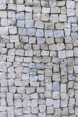 Old gray small stone wall, a beautiful background for the designer, copy empty space, vertical photo