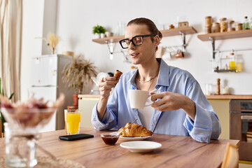 Young handsome man enjoying breakfast and coffee in a cozy kitchen setting
