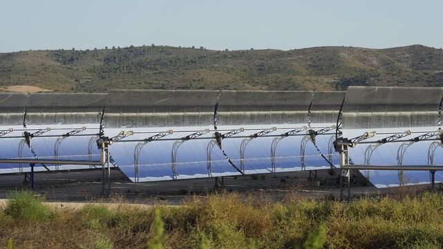 Solar thermal power plant with parabolic mirrors in a dry landscape. Renewable energy technology for clean electricity production and environmental sustainability.