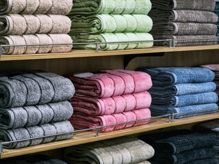 Soft towels arranged neatly on shelves in a retail store during shopping hours