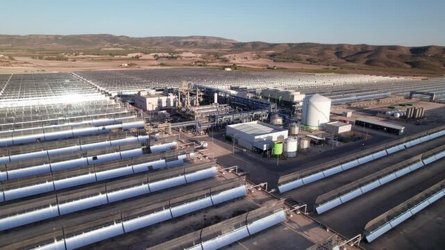 Solar thermal power plant with parabolic mirrors in a dry landscape. Renewable energy technology for clean electricity production and environmental sustainability.