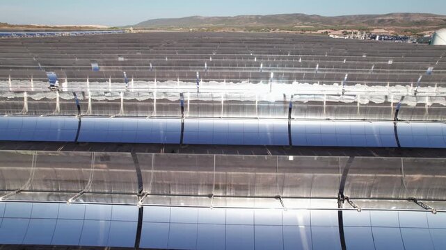 Solar thermal power plant with parabolic mirrors in a dry landscape. Renewable energy technology for clean electricity production and environmental sustainability.