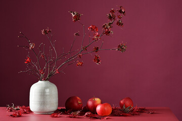 Autumnal decoration of maple branches and red apples