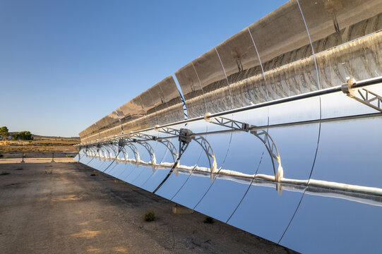 Solar thermal power station with rows of parabolic trough mirrors reflecting sunlight. Renewable energy facility showcases cutting-edge technology for sustainable electricity generation.