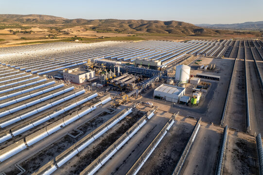 Solar thermal power station with rows of parabolic trough mirrors reflecting sunlight. Renewable energy facility showcases cutting-edge technology for sustainable electricity generation.