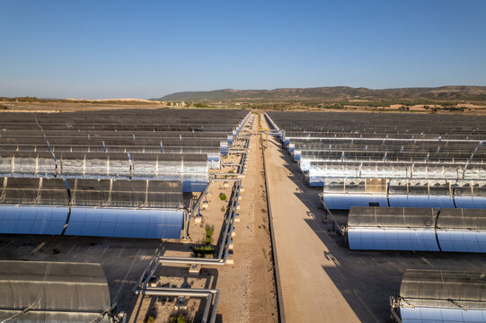 Solar thermal power station with rows of parabolic trough mirrors reflecting sunlight. Renewable energy facility showcases cutting-edge technology for sustainable electricity generation.