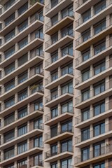 Fototapeta premium Frontal view of residential facade with repeating balconies