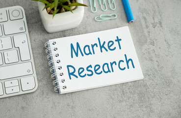 A white notebook with blue writing that says Market Research