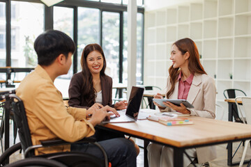 Group of business people in a meeting with man on a wheelchair for inclusion. Young businessman greeting business partner and team. Coworker on wheelchair
