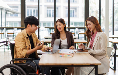 Group of business people in a meeting with man on a wheelchair for inclusion. Young businessman greeting business partner and team. Coworker on wheelchair
