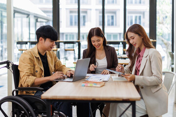 Group of business people in a meeting with man on a wheelchair for inclusion. Young businessman greeting business partner and team. Coworker on wheelchair
