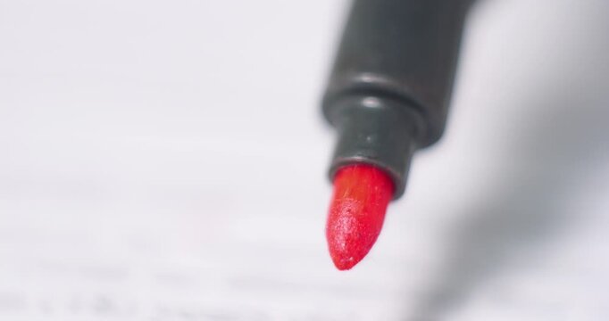 Detailed close-up of a red marker tip poised above paper, emphasizing the rich color and smooth texture of the ink, perfect for artistic expression and design projects with copy space