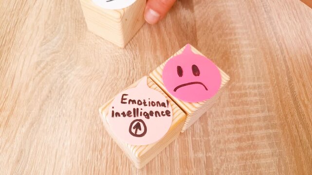 EMOTIONAL INTELLIGENCE text, inscription with drawn emoticons and emotions on cubes. Psychological health, concept.