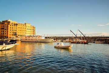 Scorcio del porto di Camogli con barche ormeggiate e luce dorata sul mare