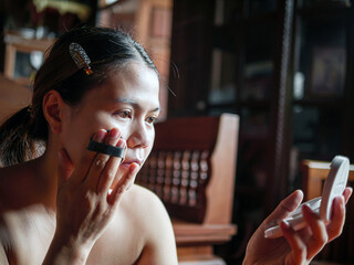 Beauty & Skincare, Beautiful woman sitting applying translucent face powder when doing make-up, Asian Female Holding Compact Powder And Applying On Face