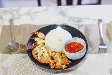 Picked Mud Crab with Rice and Dipping Sauce on a Black Plate