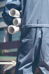 Fototapeta premium Construction engineer man hold blueprint wear blue shirt safety white hard hat at construction site industry labor worker. Architecture man engineer civil worker look at blueprint real estate concept