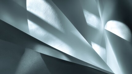 A close-up view of textured paper with dynamic lighting, showcasing folds and shadows in a minimalist, abstract composition.