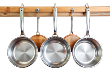 Shiny silver skillets hung on wooden rails isolated on a transparent background frying pan