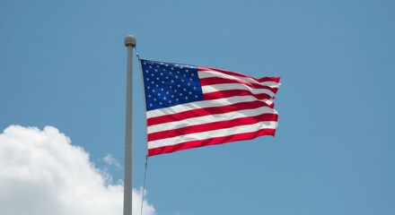 Fototapeta premium The American flag waving proudly in the breeze under a clear blue sky showcasing patriotism and