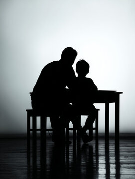 Silhouette of a kind teacher or parent guiding a young child at a school desk. A powerful concept of education, mentorship, and learning support. World Teachers' Day, International Day of Education