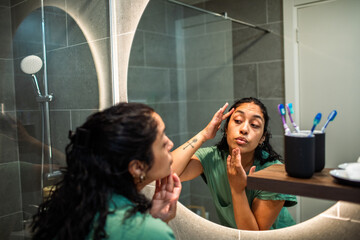 Woman applying skincare in bathroom
